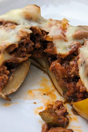 Stuffed portobello mushroom cut open to see the inside which is chorizo and peppers and topped with melted mozzarella cheese.