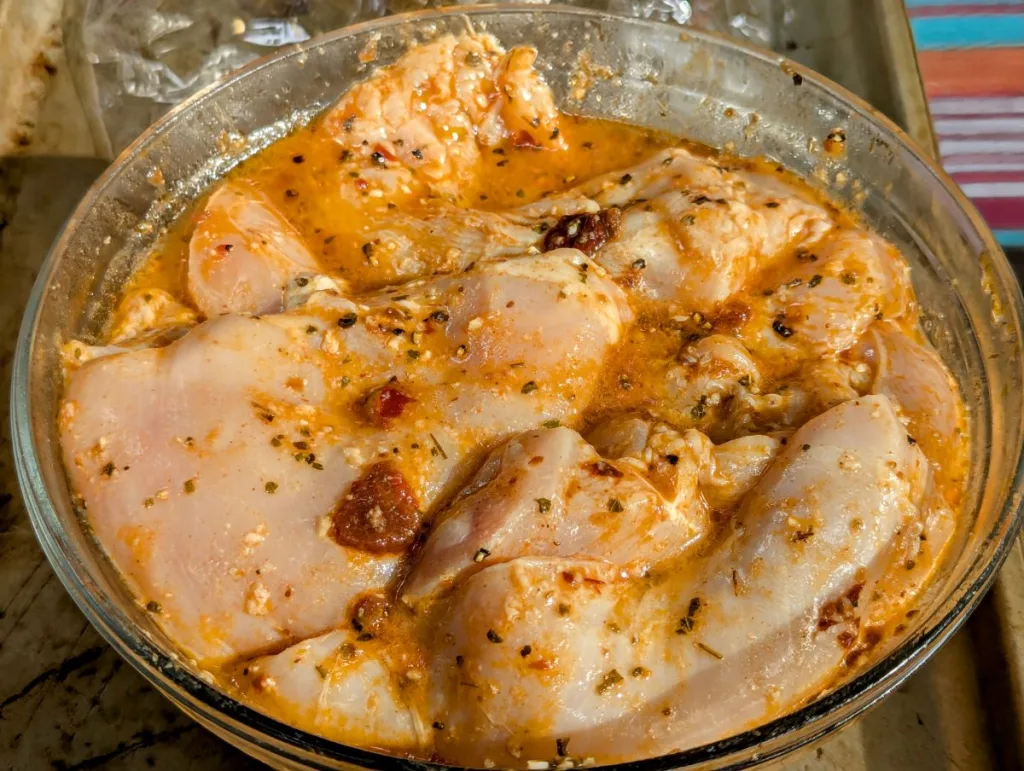 Chicken breasts in a bowl of chipotle lime marinade.