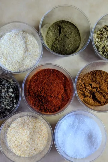Clear containers of spices to make creole seasoning.