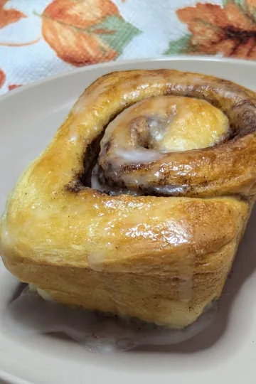 A pumpkin spice bun on a plate.