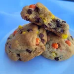 Two Reese's Pieces cookies with half a cookie lying on top.