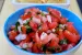 A small bowl filled with fresh salsa. There is a dish of tortilla chips behind it.