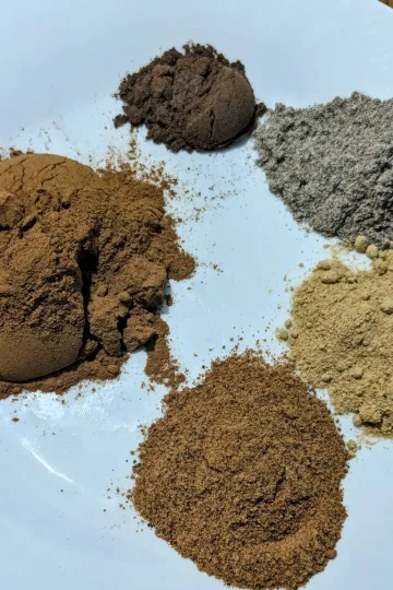 All the spices needed to make apple pie spice on a white plate.