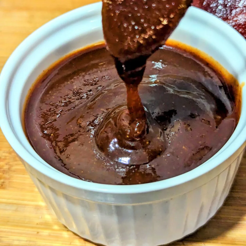 a small white bowl filled with Apple Brown Sugar BBQ Sauce.
