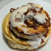 One bacon cinnamon bun with maple icing and bacon crumble on top.