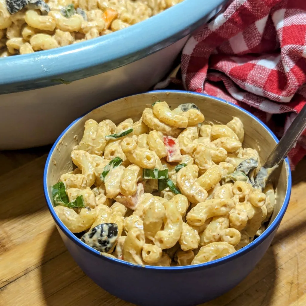 A small bowl of chipotle ranch macaroni salad with a larger bowl barely seen in the back.