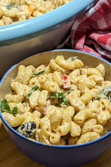A small bowl of chipotle ranch macaroni salad with a larger bowl barely seen in the back.