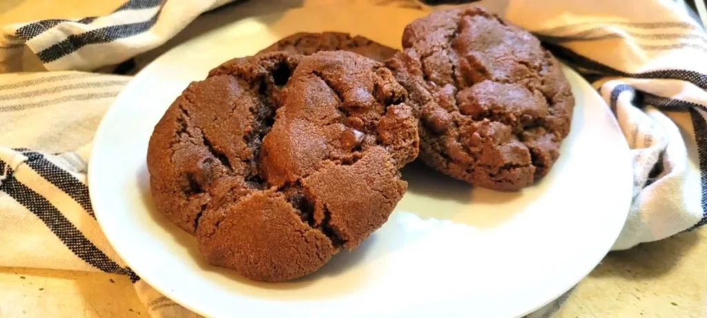 A plate of Nesquik Chocolate Chip Cookies with a blue and white towel in the back of the plate.