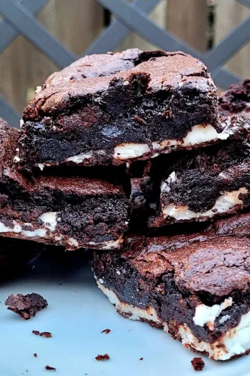 Peppermint patty brownies piled on a plate.