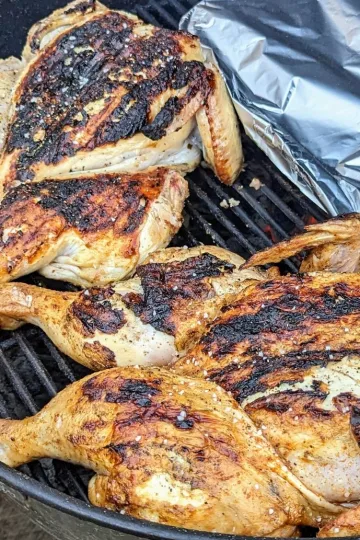 Two Peruvian marinated chickens on a BBQ.