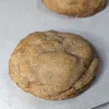 A soft cinnamon cookie on a parchment lined pan.