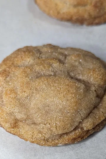 A soft cinnamon cookie on a parchment lined pan.