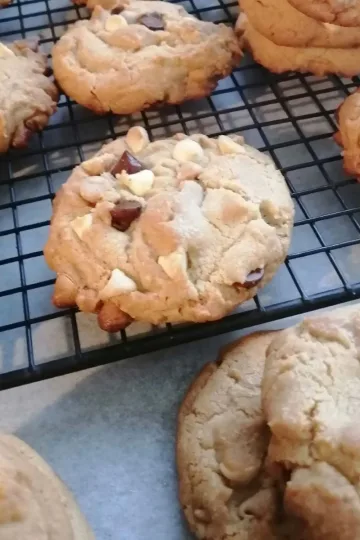 Triple chocolate chip cookies on a cooling rack.
