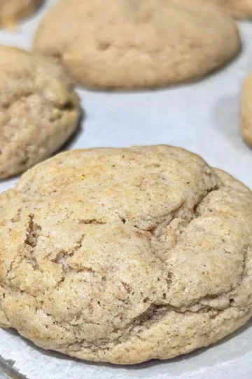 Gingerbread cream cheese cookies on a parchment lined cookie sheet.