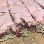 Cherry Chews bars cut into squares on a piece of wood.