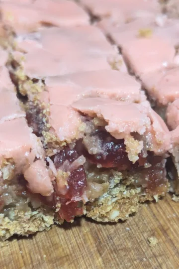 Cherry Chews bars cut into squares on a piece of wood.