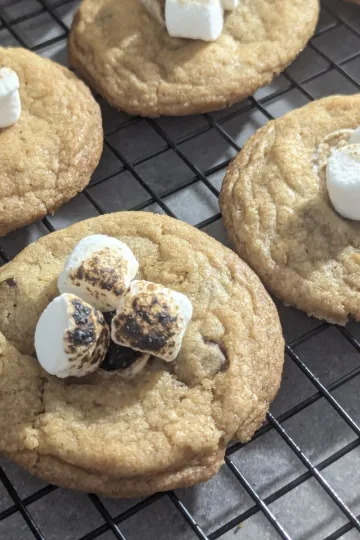 Four S'mores cookies on a wire rack.