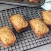 Four mini oatmeal loaves on a wire rack.