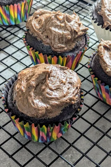 Chocolate cupcakes in rainbow wrappers with chocolate buttercream icing.