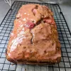 Glazed strawberry banana bread on a cooling rack.