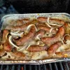 brats in beer with onions on the BBQ.