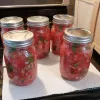 Five jars of homemade salsa on white paper towels.