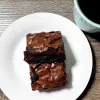 Two squares of espresso brownies on a small white plate.