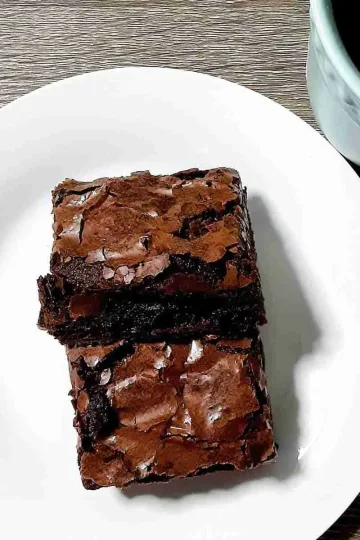 Two squares of espresso brownies on a small white plate.