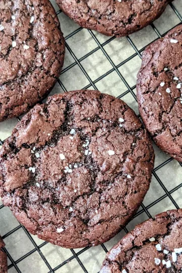 Salted chocolate cookies on a wire rack.