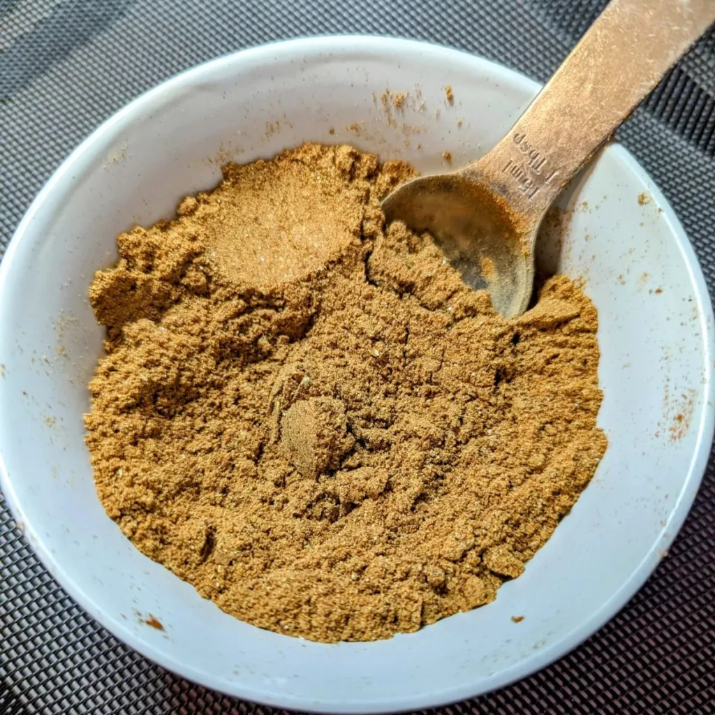 A small bowl of Homemade Taco Seasoning with a spoon in it.