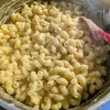 Easy stovetop mac and cheese in a pot with a red spoon in it.