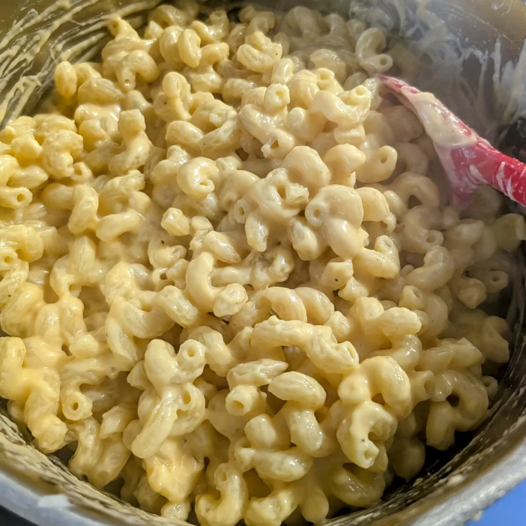 Easy stovetop mac and cheese in a pot with a red spoon in it.