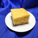A piece of pineapple cake on a white plate.
