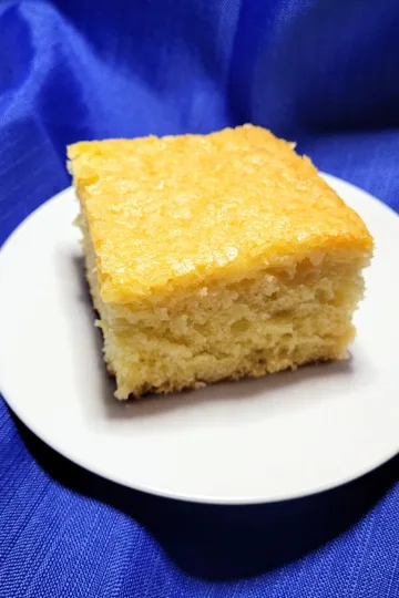 A piece of pineapple cake on a white plate.