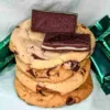 Four Andes Mint cookies stacked in a pile with two Andes chocolates on top.