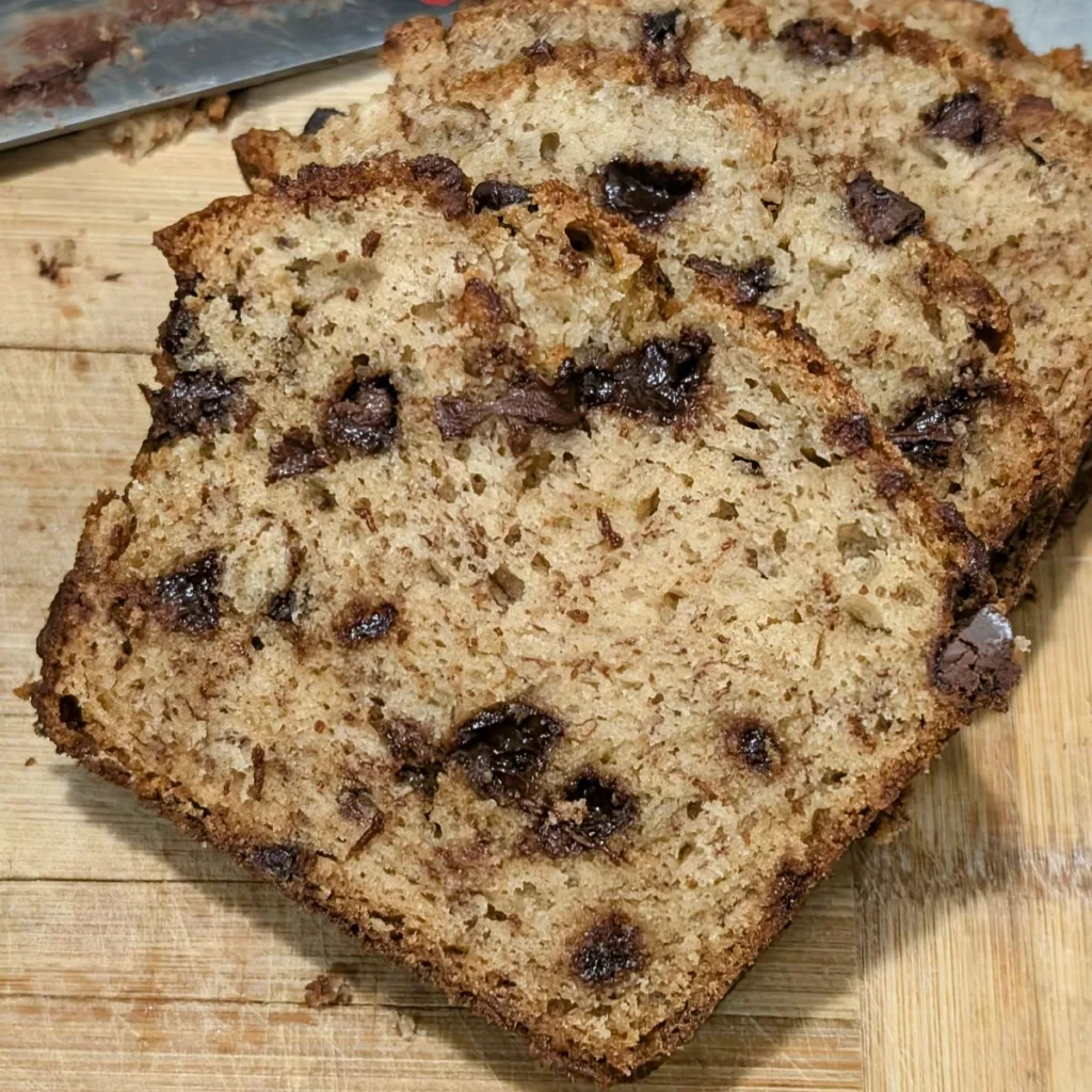 Sliced Banana Bread with Chocolate Chips on a wooden cutting board.