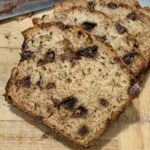 Sliced Chocolate Chip Banana Bread on a wooden cutting board.