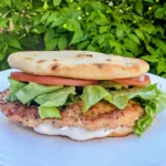 Blackstone Spiced Chicken sandwich on Naan with lettuce, tomato and mint yogurt sauce.