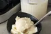 A bowl of Homemade Ice Cream with a spoon. There is a container of ice cream behind it.