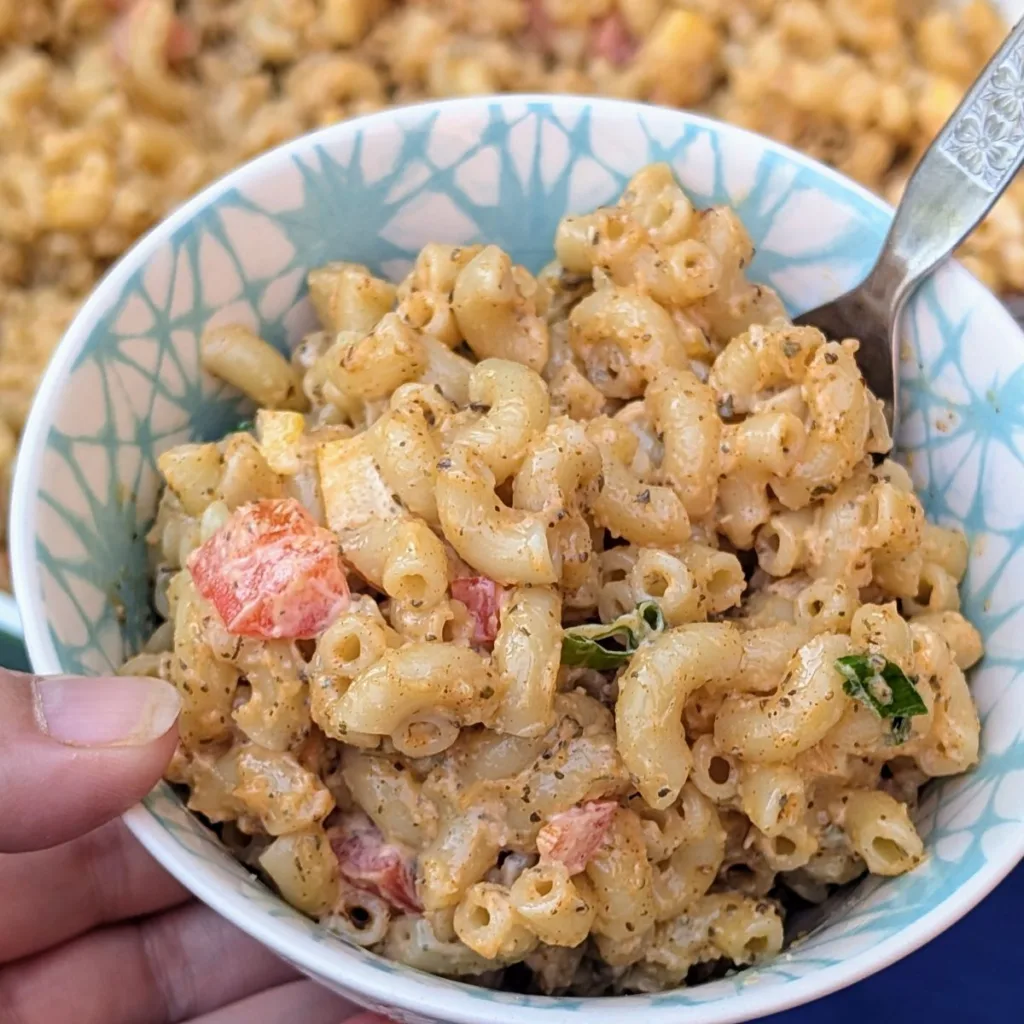 Kraft Copycat Macaroni Salad in a bowl with a fork being held in a hand.
