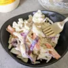 a bowl of honey Dijon coleslaw with a fork.