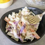 a bowl of honey Dijon coleslaw with a fork.