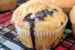 Blueberry Peach Muffin on a cooling rack with more Blueberry Peach Muffins behind the muffin.