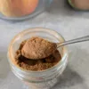 A spoonful of Apple Pie Spice over a jar of spice.